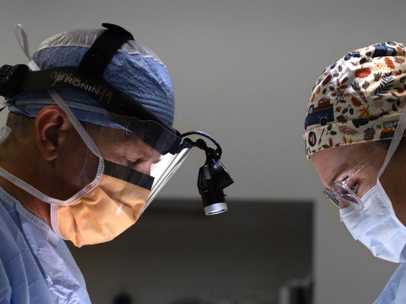 Male surgeon in the operating room with a female medical staff attendant.