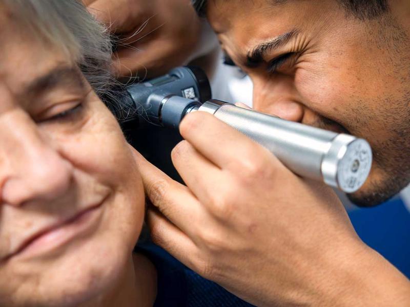 Dr. Varun Patel uses an otoscope to examine a patient’s inner ear while assessing the cause of her vertigo.