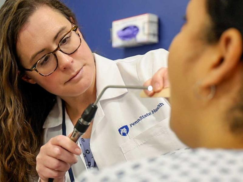A healthcare professional providing care to a patient in a clinical setting.